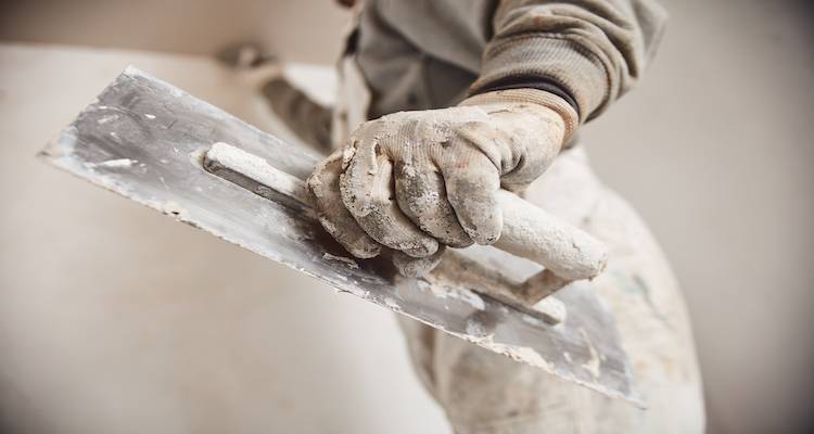 closeup of a plasterer holding work tool