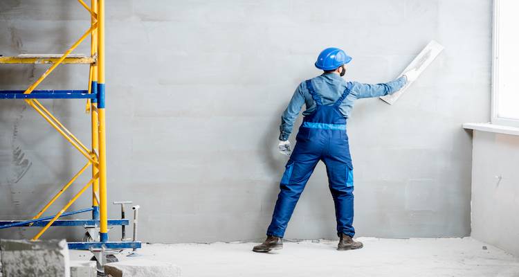 tradesperson in the process of plastering an internal wall