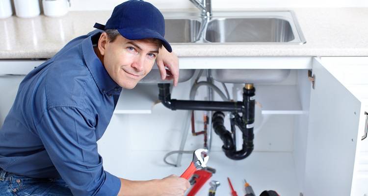 plumber working under sink