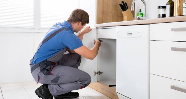 man installing kitchen cupboard door