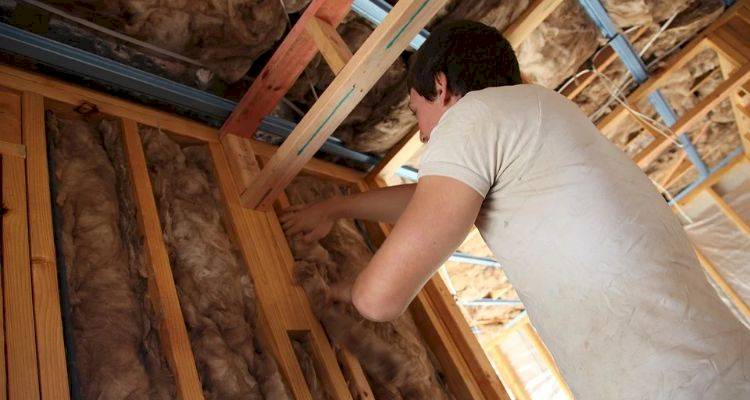 roof insulation cost guide — tradesperson fitting roof insulation in a UK home