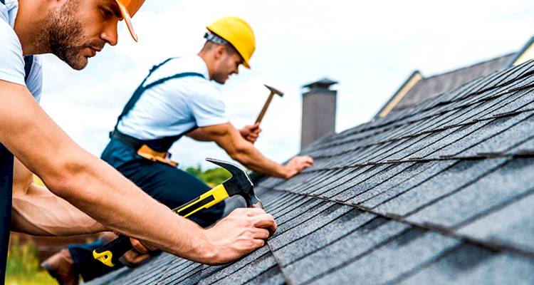 Two men repairing a roof