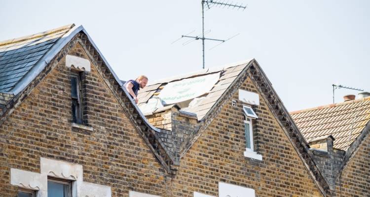 person fixing roof on terrace house