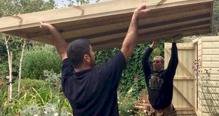 Two men repairing shed
