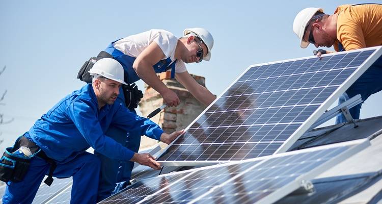 three workers fitting solar