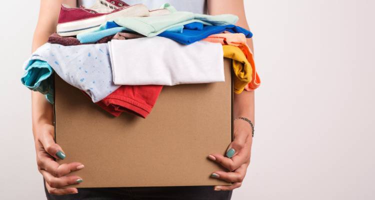 person holding box of clothes