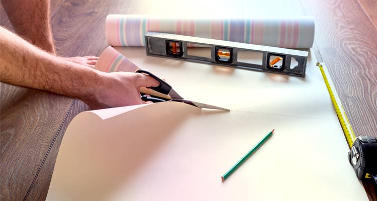 Man cutting wallpaper