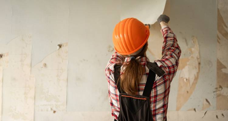 woman stripping wallpaper