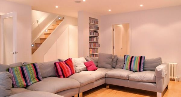 Basement with large u shape sofa and colourful cushions for comfortable home extension ideas