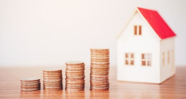 Coins stacked next to a house