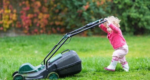 child pushing lawn mower