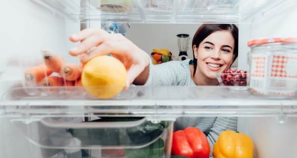 Female reaching inside of a fridge