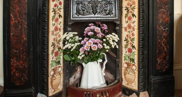 victorian fireplace with flowers inside it