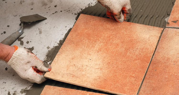 person tiling a floor