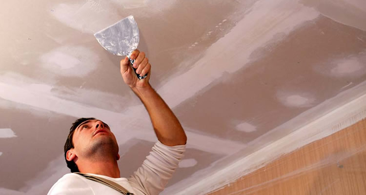 person filling a ceiling