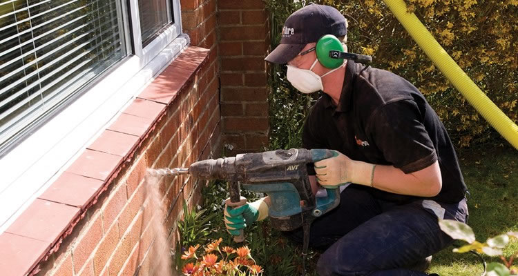 someone installing cavity wall insulation