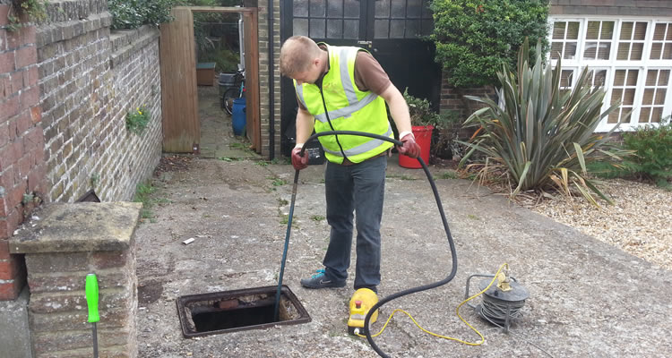 person unblocking drains